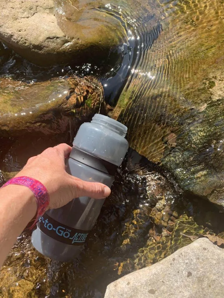 Refilling my water to go go bottle in a mountain stream